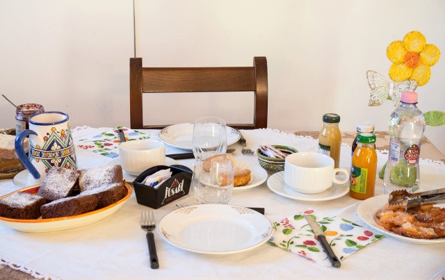 Colazione abbondante con torte, dolcetti e marmellate.